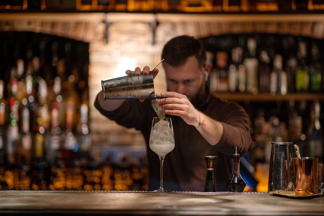 Baarimikko valmistaa näyttävää jäillä täytettyä cocktailia tiskillä